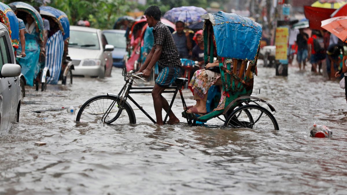 Dhaka, Bangladesh - July 24, 2018: Vehicles try to drive through a flooded street in Dhaka, Bangladesh. Encroachment of canals is contributing to the continual water logging in the Capital Dhaka.