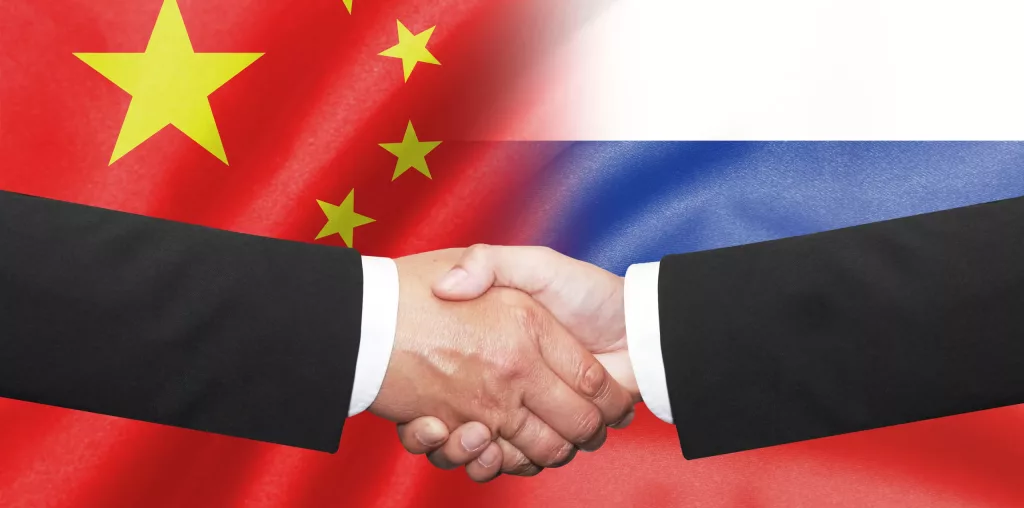 Two,Business,Man,Shakehand,On,China,And,Russian,Flag