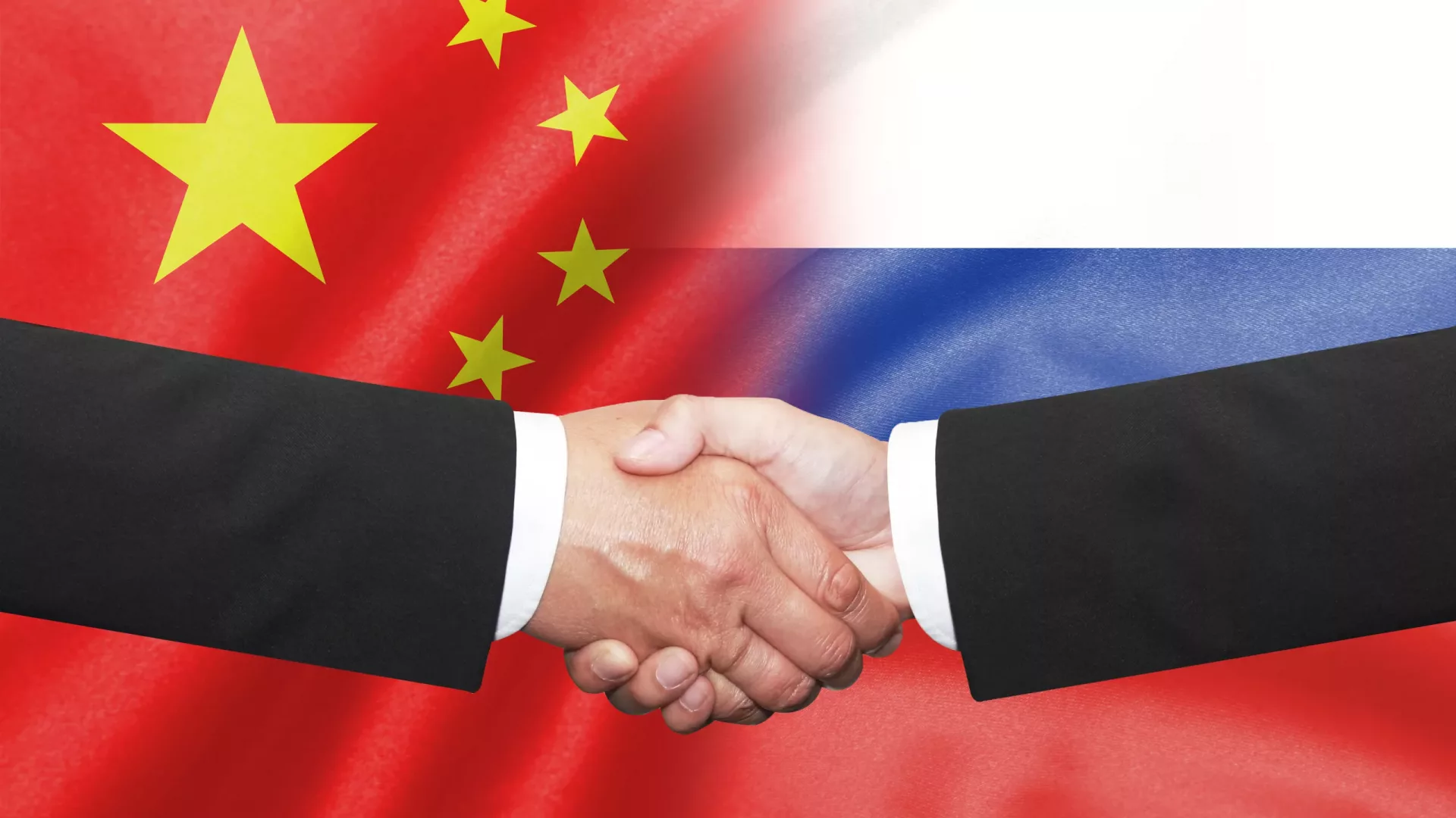 Two,Business,Man,Shakehand,On,China,And,Russian,Flag